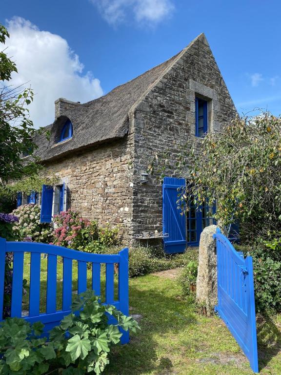 une vieille maison en pierre avec des portes bleues et une clôture bleue dans l'établissement Travel Breizh - Vivez l'authenticité, à Pont-Aven