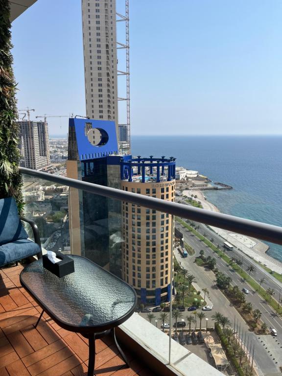 un balcon avec un banc et une vue sur l'océan dans l'établissement شقةباأطلالة بحرية برج الجوهره داماك Damac AlJawharah Tower, à Quai