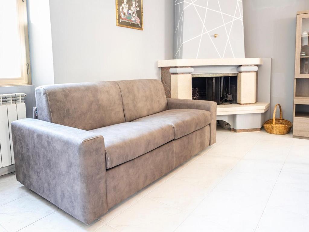 a brown couch in a living room with a fireplace at Domus Albano laziale in Albano Laziale