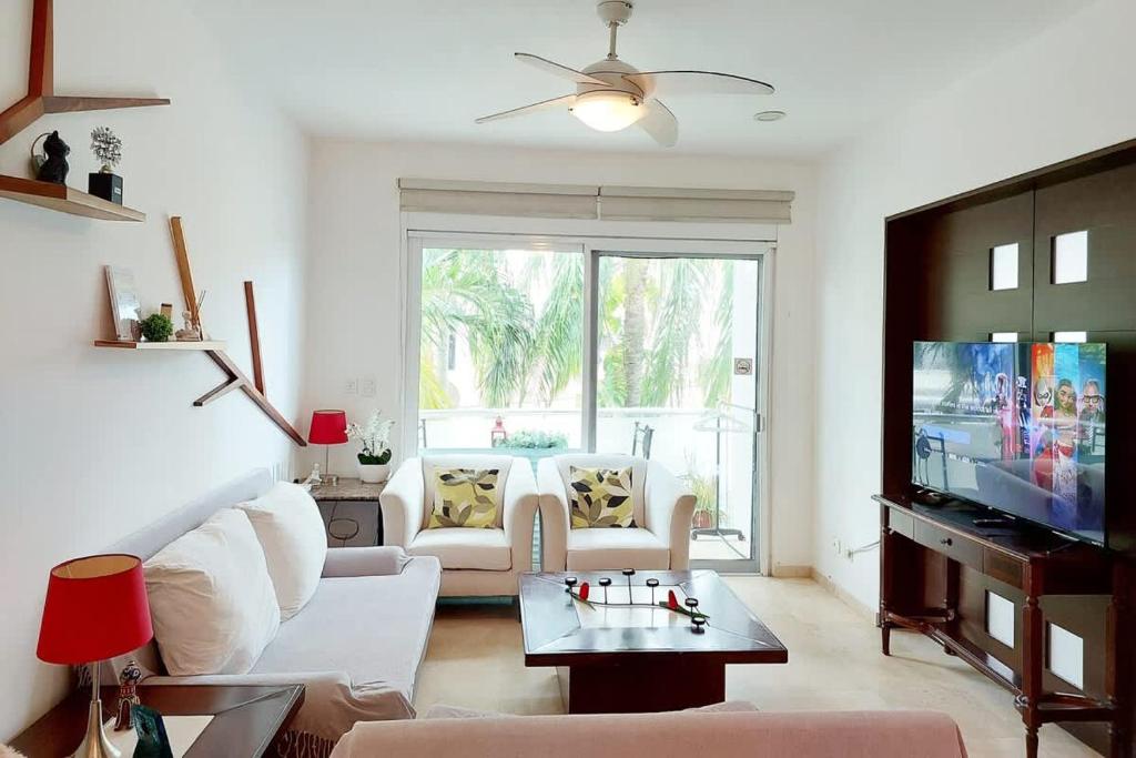 un soggiorno con un divano bianco e una TV di Oceanview Pool Near Av 5th Beach 6 Guest Fast WiFi a Playa del Carmen