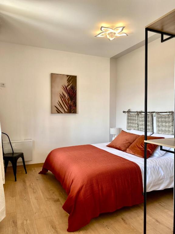 une chambre avec un lit avec une couverture rouge dans l'établissement L'Espérance vue sur la Loire et la vigne 2, à Pouilly-sur-Loire