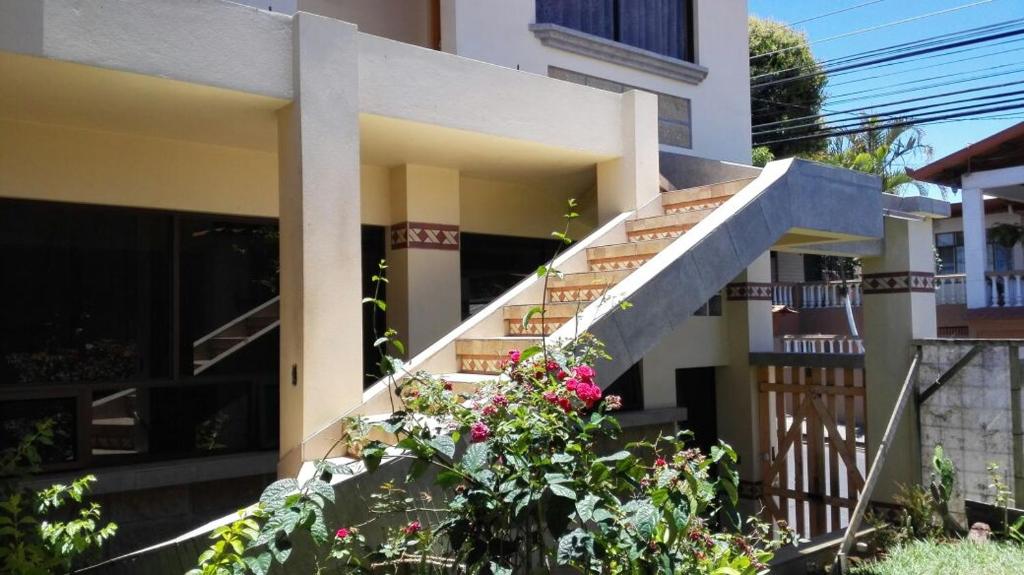 une maison avec des escaliers et des fleurs devant elle dans l'établissement Morada Kampos, à Heredia