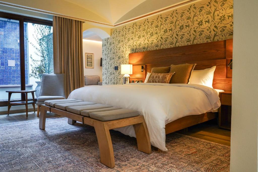 a bedroom with a large bed and a chair at Casa Postal Hotel Boutique in Querétaro