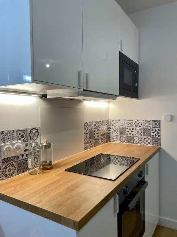 - une cuisine avec un comptoir en bois et un four micro-ondes dans l'établissement Studio Cosy Vannes Centre, à Vannes