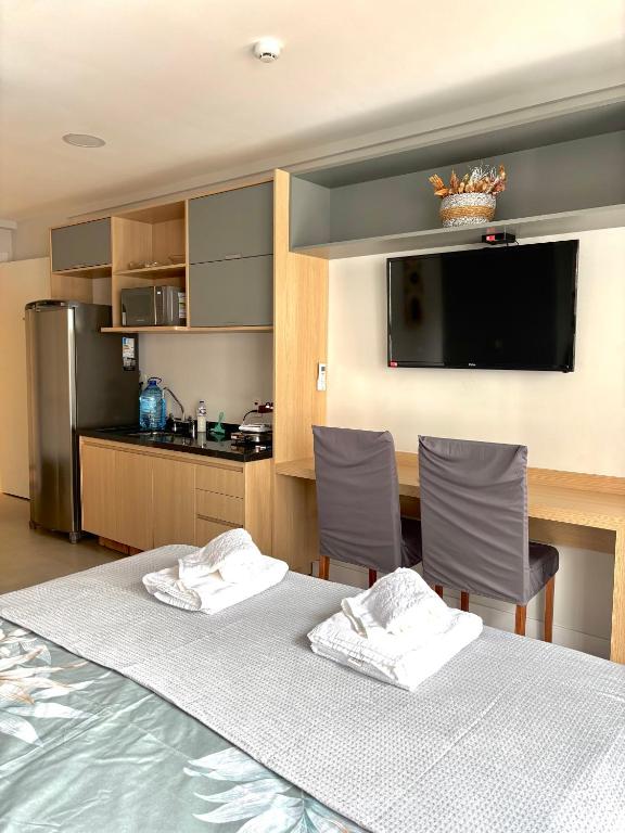 a room with a table and chairs and a kitchen at Flat Mirant Vila Madalena in São Paulo