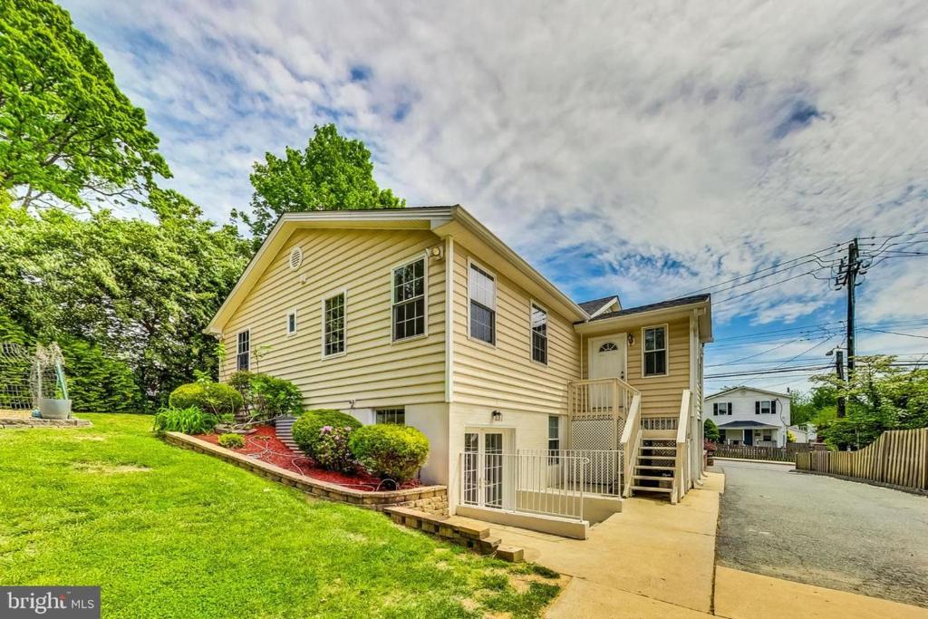 a yellow house with a fence and a yard at Entire Family-friendly 4 BR Cozy Unit , Metro walk in Rockville
