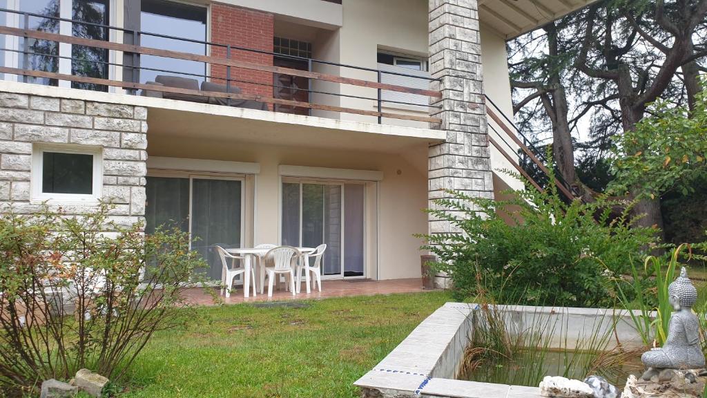 Saint-Vincent-de-PaulにあるGrand T3 rénové - Calme Jardin Parking Wifi proche DAXのテーブルと椅子のあるパティオのある家