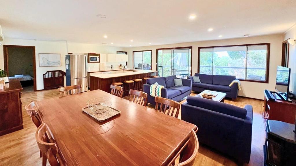 a living room with a wooden table and a kitchen at Dunsborough Delight in Dunsborough