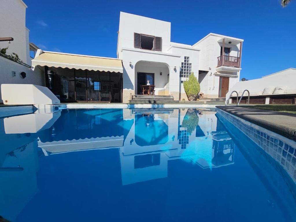 a swimming pool in front of a house at Refugio Costa Teguise - Lanzarote in Costa Teguise