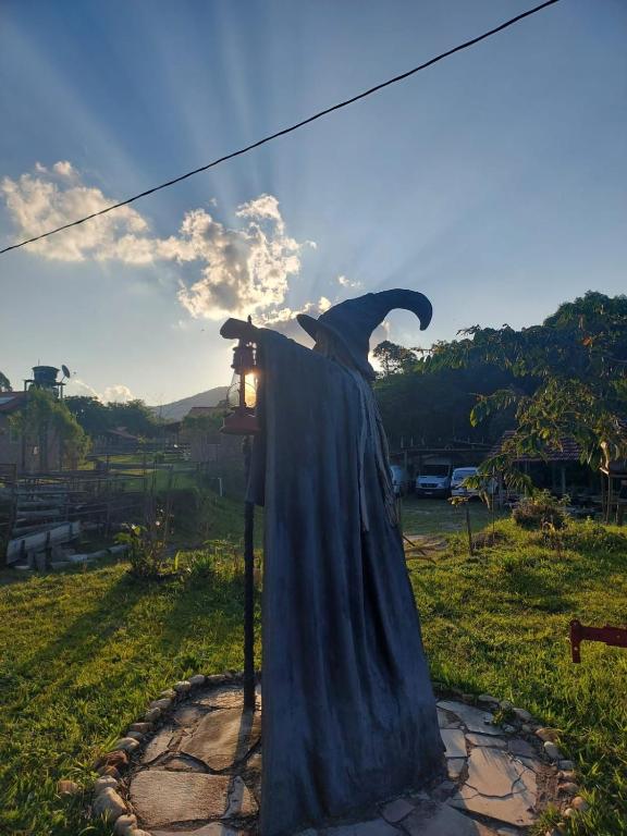 a dress on a pole in a field at Chalés e Camping Taquaral in São Thomé das Letras