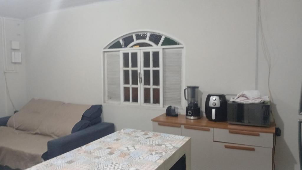 un salon avec un canapé et une fenêtre dans l'établissement Casa Glória macaé, à Macaé