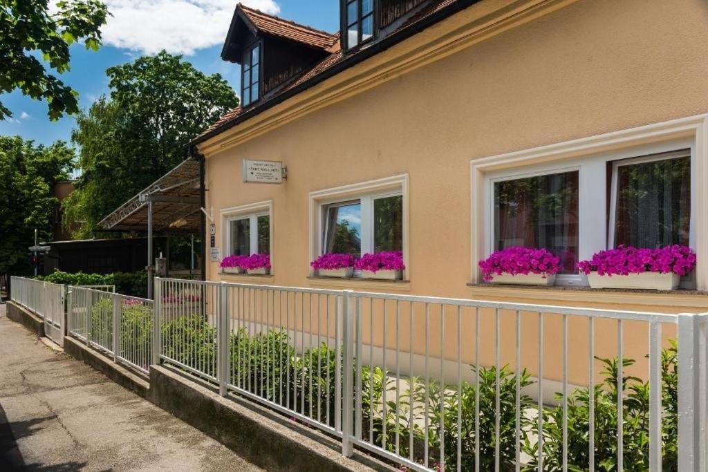 uma casa com flores roxas nas janelas em Rooms with WiFi Zagreb - 24079 em Zagreb