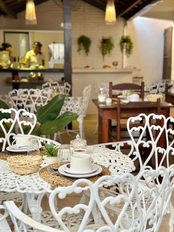 a table with white chairs and a white table cloth at Peixe Crew Rua das Pedras in Búzios