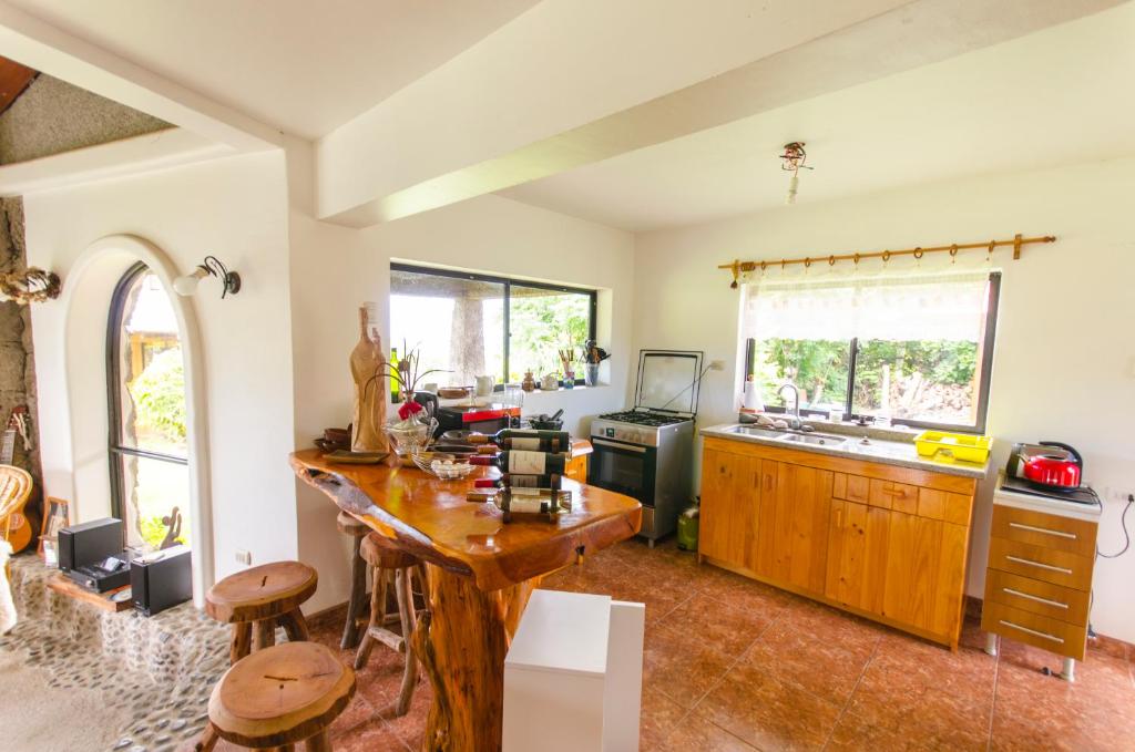 a kitchen with a wooden table and a counter at Cabañas Moai in Hanga Roa