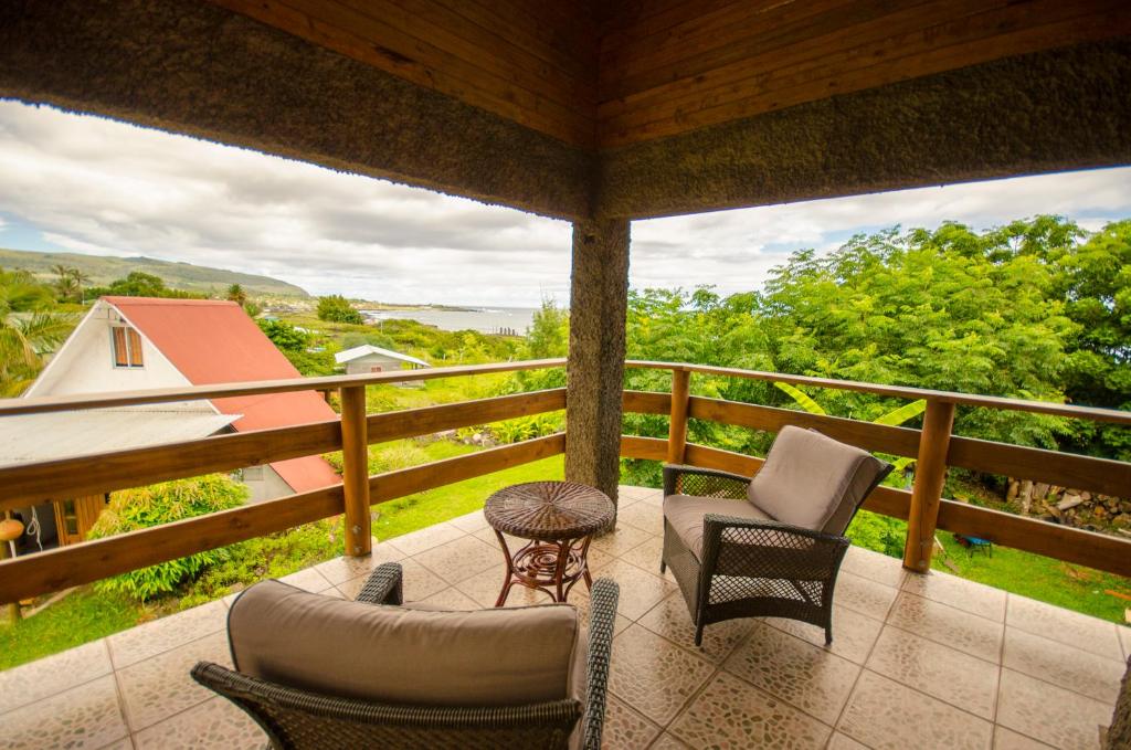 a porch with chairs and a table and a view at Cabañas Moai in Hanga Roa