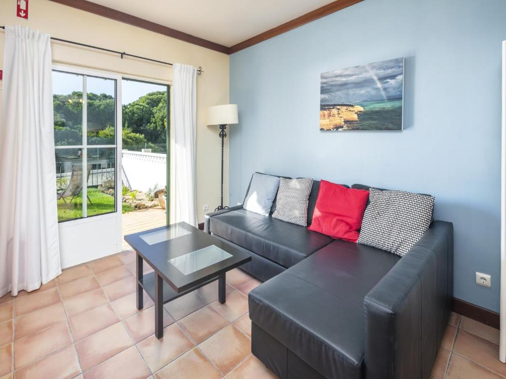 a living room with a black couch and a table at Seaside Apartment in Picturesque Benagil in Benagil