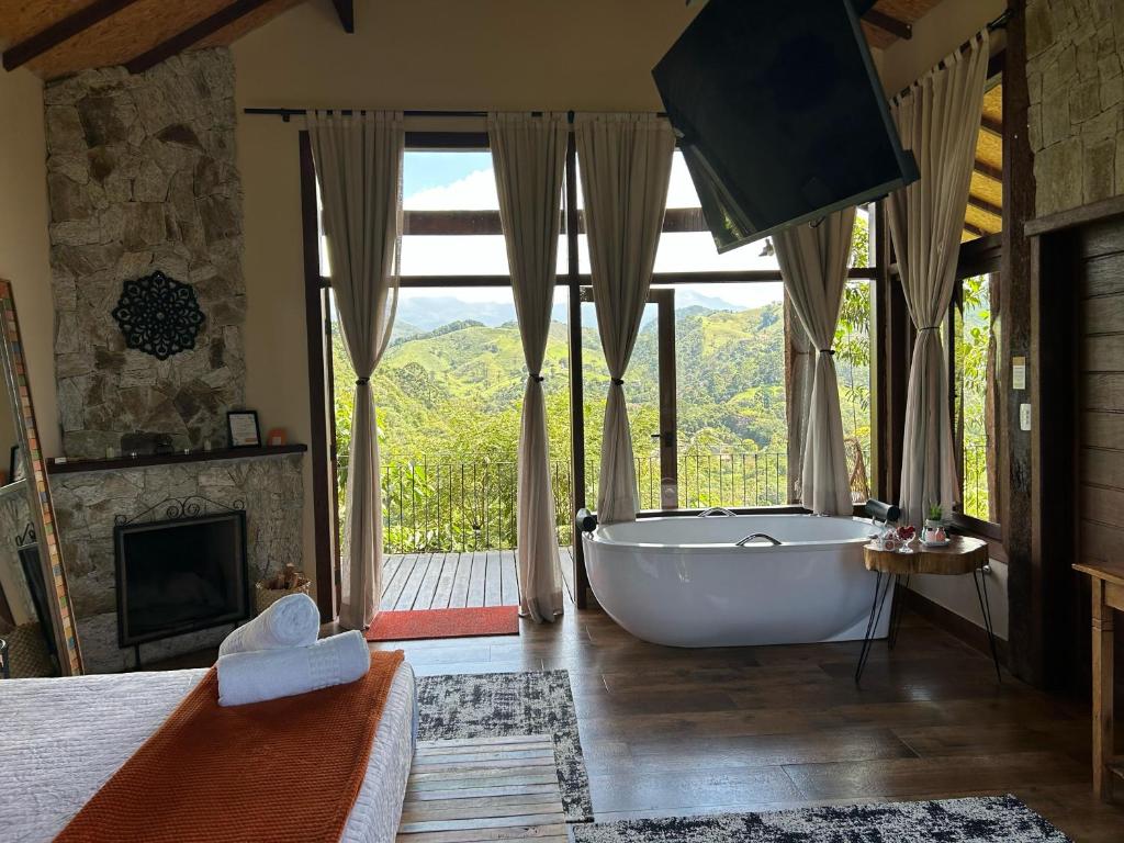 a large bathroom with a tub in front of a window at Reserva Mauá chalés in Visconde De Maua