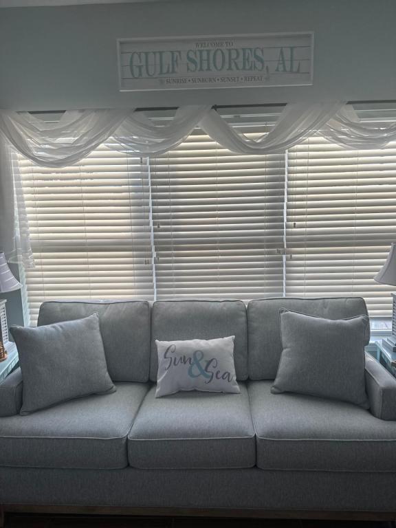ein Sofa mit einem Kissen darauf im Wohnzimmer in der Unterkunft Beautiful Two Bedroom, Two Bathroom First Floor Condo in Gulf Shores! in Gulf Shores