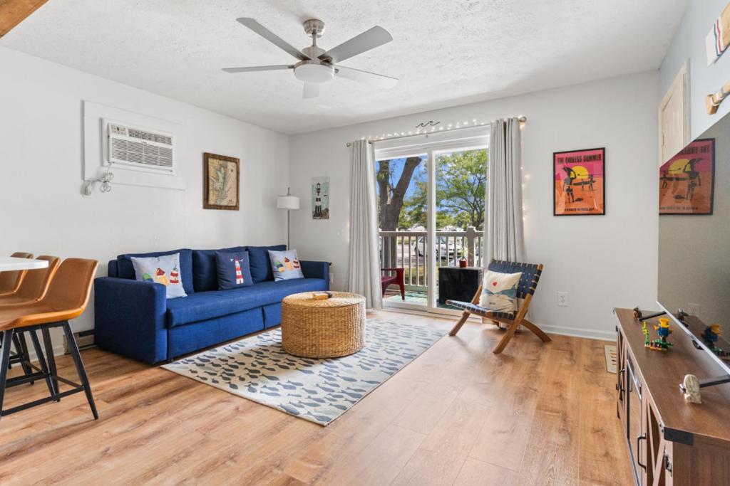 a living room with a blue couch and a table at Renovated 1-Bedroom Condo with Pool, Bikes, & Beach Access in North Ocean City, MD in Ocean City