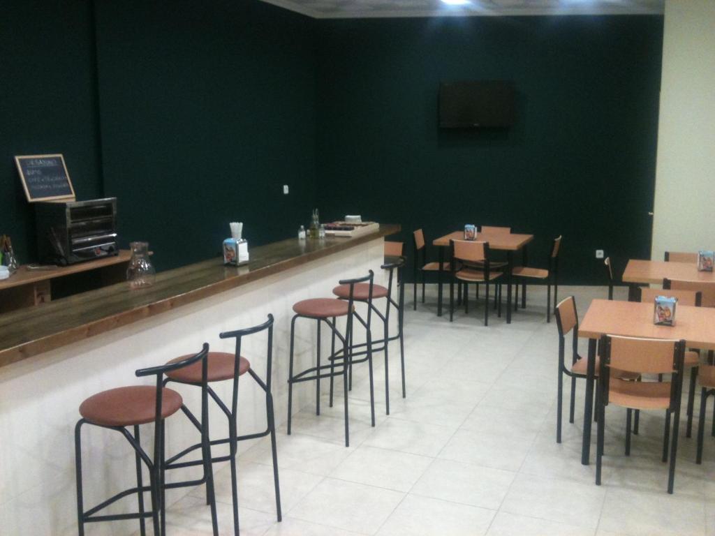 restauracja ze stołami i stołkami w barze w obiekcie Hotel RC Ramon y Cajal w mieście Cuenca