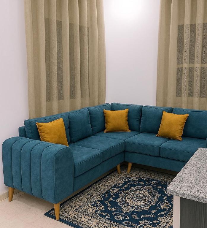 a blue couch with yellow pillows in a living room at Dar El Yasamine in Houmt Souk