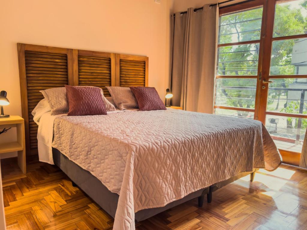 Ubicación y todo para tu desayuno في ميندوزا: غرفة نوم بها سرير ونافذة كبيرة