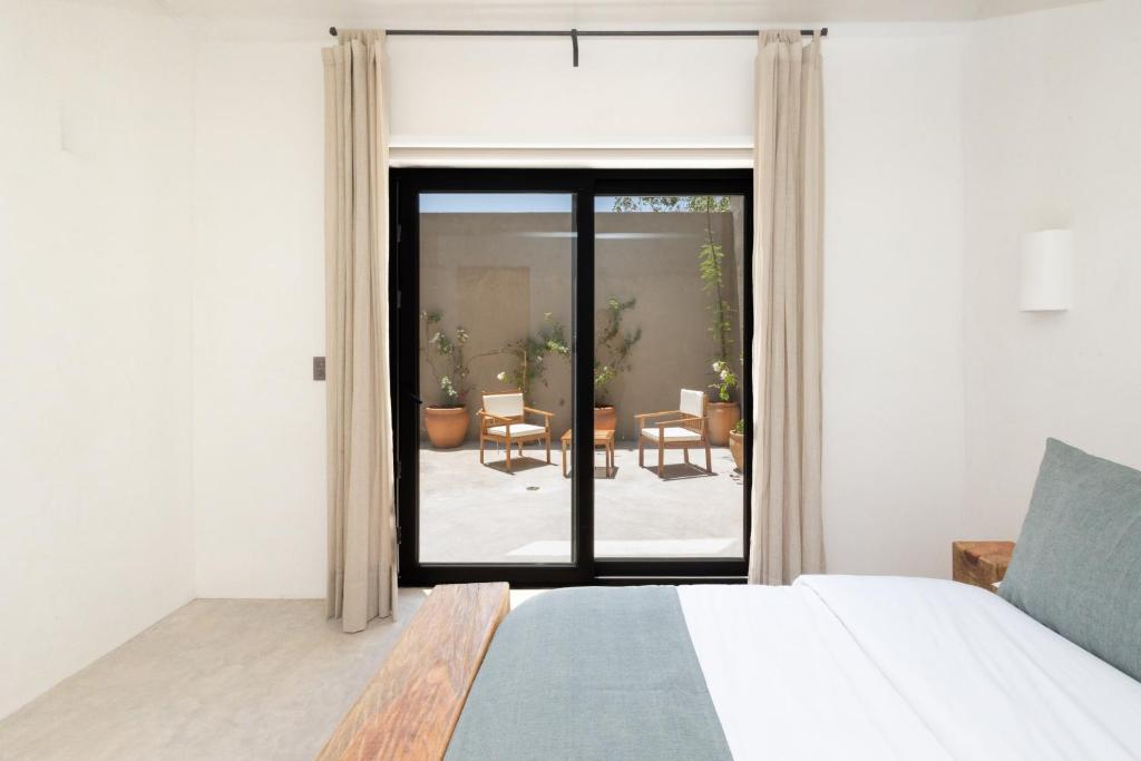 a bedroom with a bed and a view of a patio at Lepetit in Oaxaca City