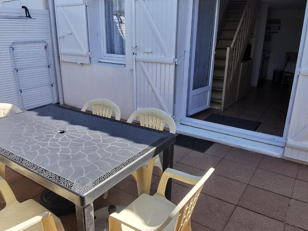 - une table et des chaises sur une terrasse couverte avec une table et des chaises dans l'établissement Dernière minute ! Pavillon T2 avec mezzanine, piscine et accès plage, La Tranche sur Mer - FR-1-357-60, à La Tranche-sur-Mer