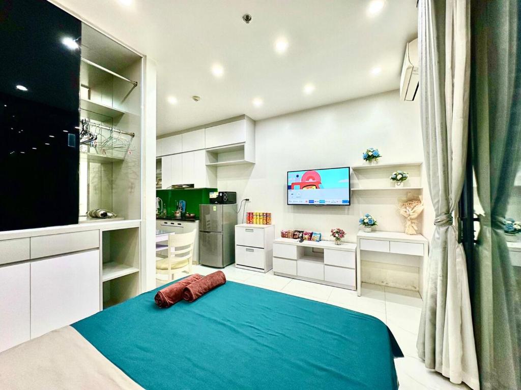 a living room with a blue bed and a tv at Cozy And Comfortable Studio Apt In City Centre Near Marriott and Keangnam in Hanoi