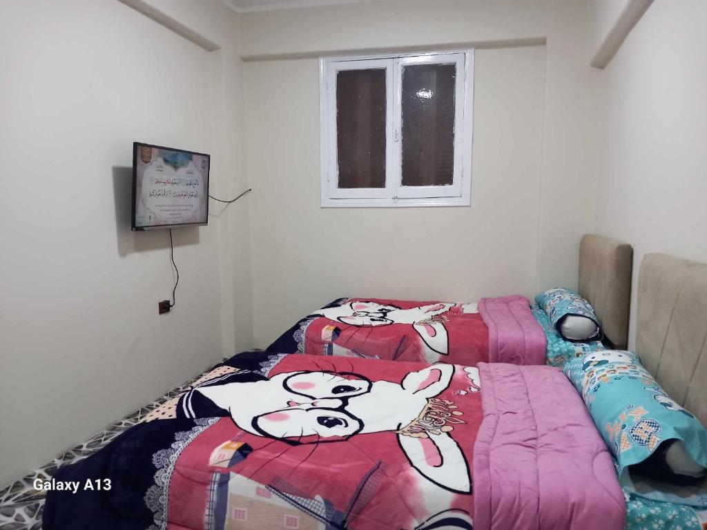 a bedroom with two beds with hello kitty blankets at شقة سكنية in Shibīn al Kawm