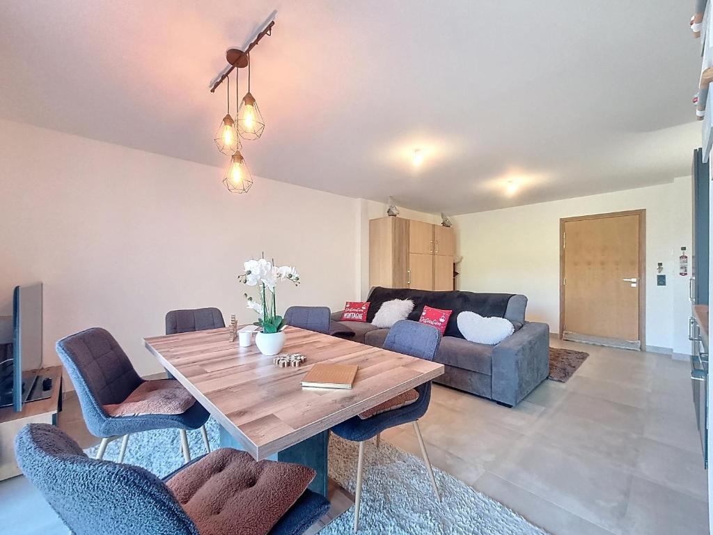 un salon avec une table et un canapé dans l'établissement Bel appartement à Combloux, accès ski et WiFi - FR-1-560-157, à Combloux