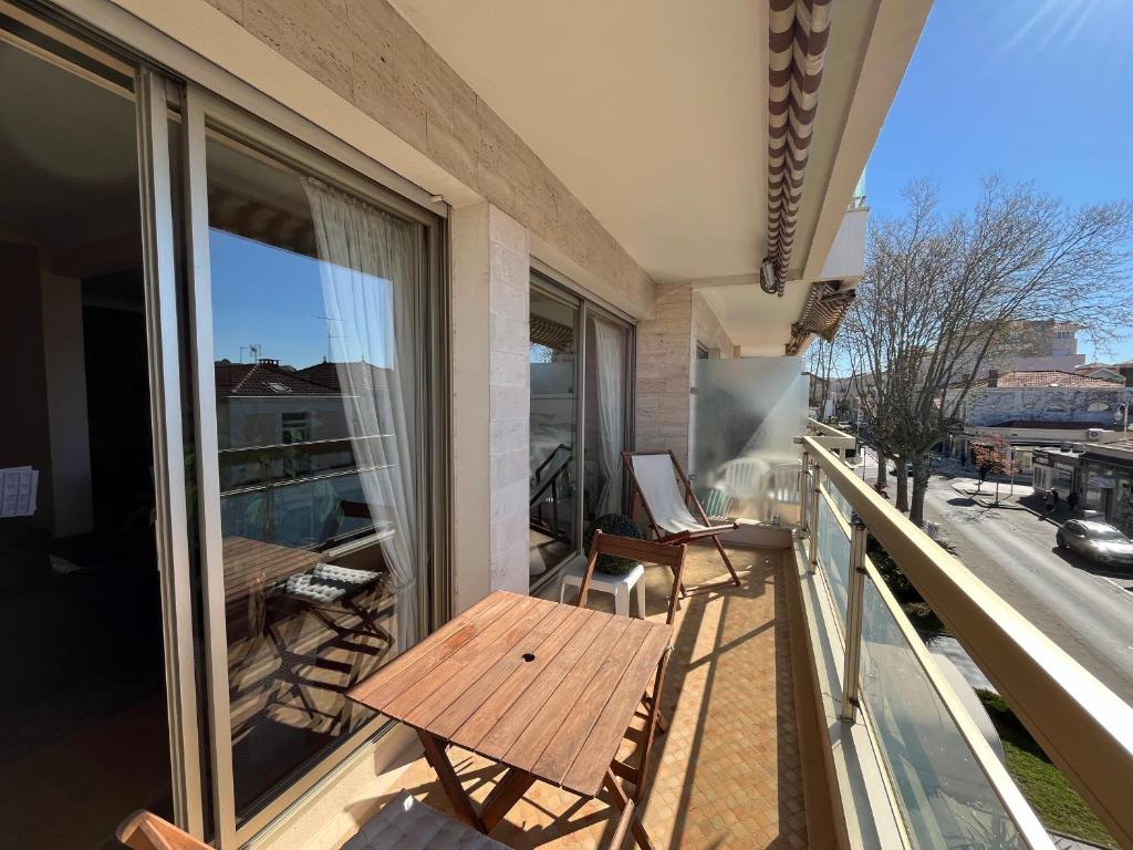 Elle comprend un balcon avec une table et des chaises en bois. dans l'établissement Arcachon: Appartement T2 bis proche centre et plage avec parking - FR-1-319-595, à Arcachon