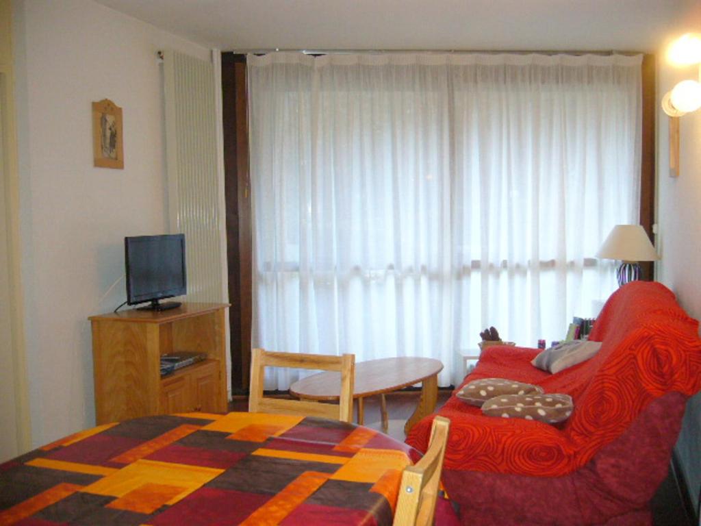 Cette chambre comprend un lit, une table et une télévision. dans l'établissement 2 pièces au pied des pistes - 6 pers, balcon, cuisine équipée - FR-1-689-152, à Villard-de-Lans