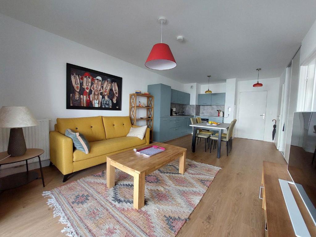 un salon avec un canapé jaune et une table dans l'établissement Appartement à 2 pas de la plage avec parking à Royan - FR-1-550-90, à Royan