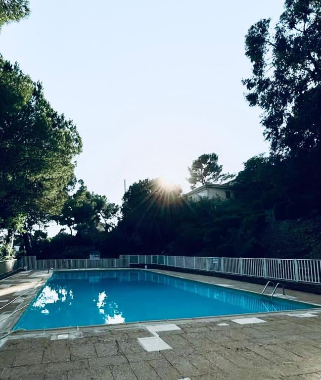 une piscine bleue avec le soleil en arrière-plan dans l'établissement Studio vue mer, à La Seyne-sur-Mer