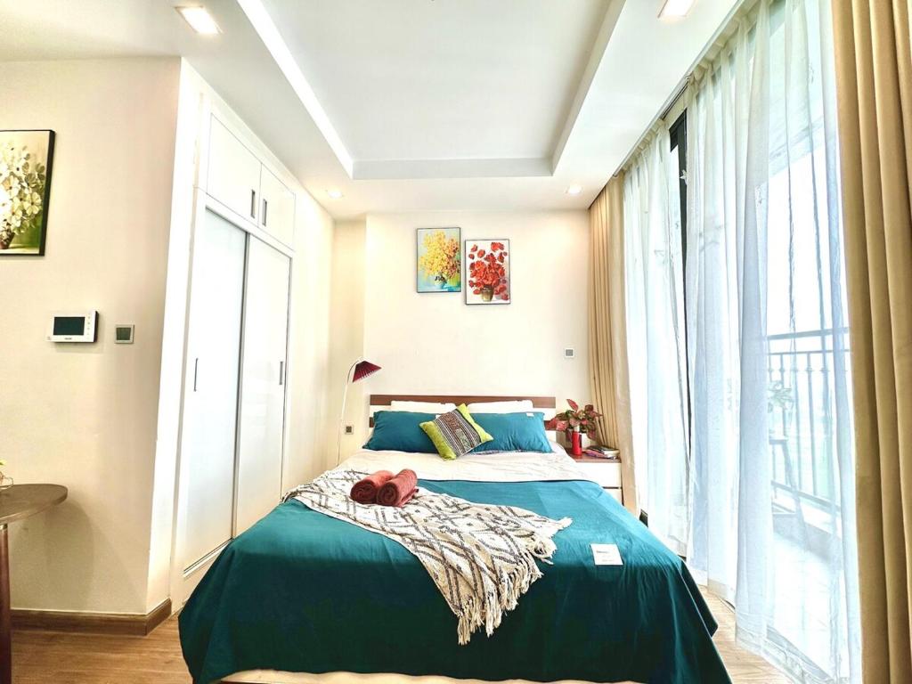 ein Schlafzimmer mit einem Bett mit einem roten Stofftier drauf in der Unterkunft Walking Lake, Pool, Gym, Tennis & Volleyball Yard Delux Studio Apt in Hanoi