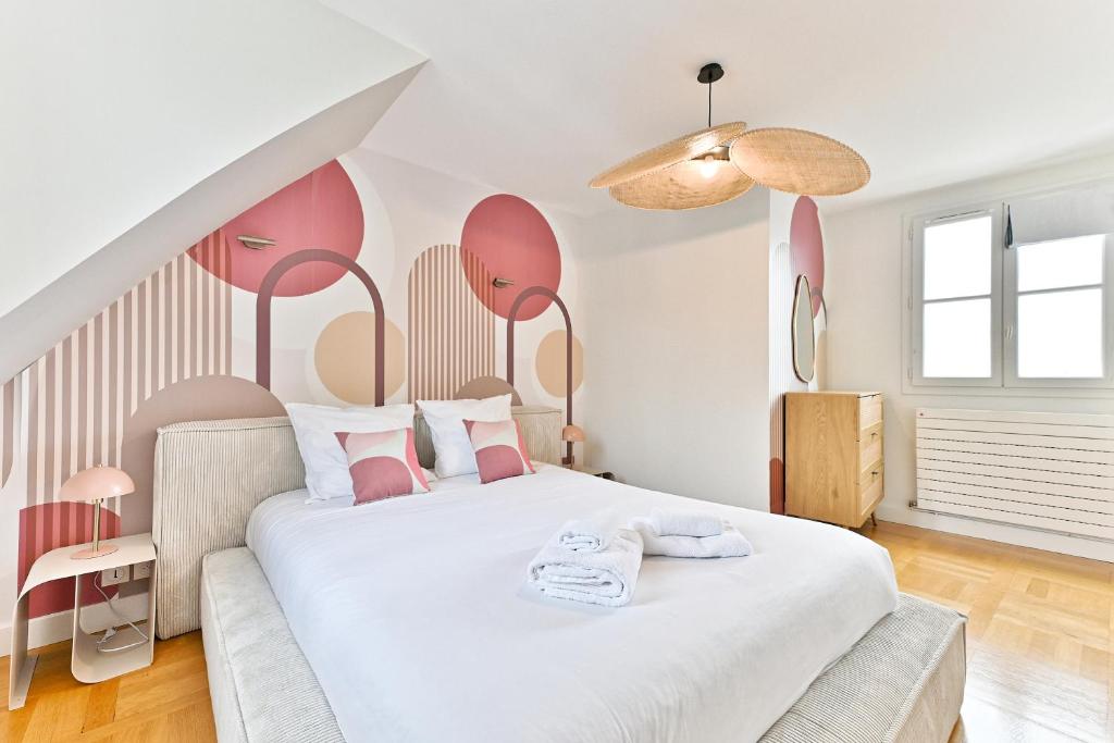 - une chambre avec un grand lit blanc aux accents roses dans l'établissement Lumineux & spacieux - Vue dégagée, Arc de Triomphe, à Paris