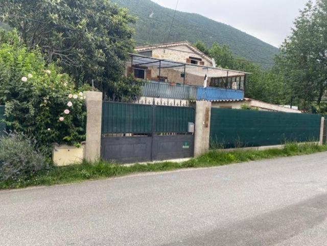 a house on the side of a road with a fence at Maison de campagne in Roquestéron