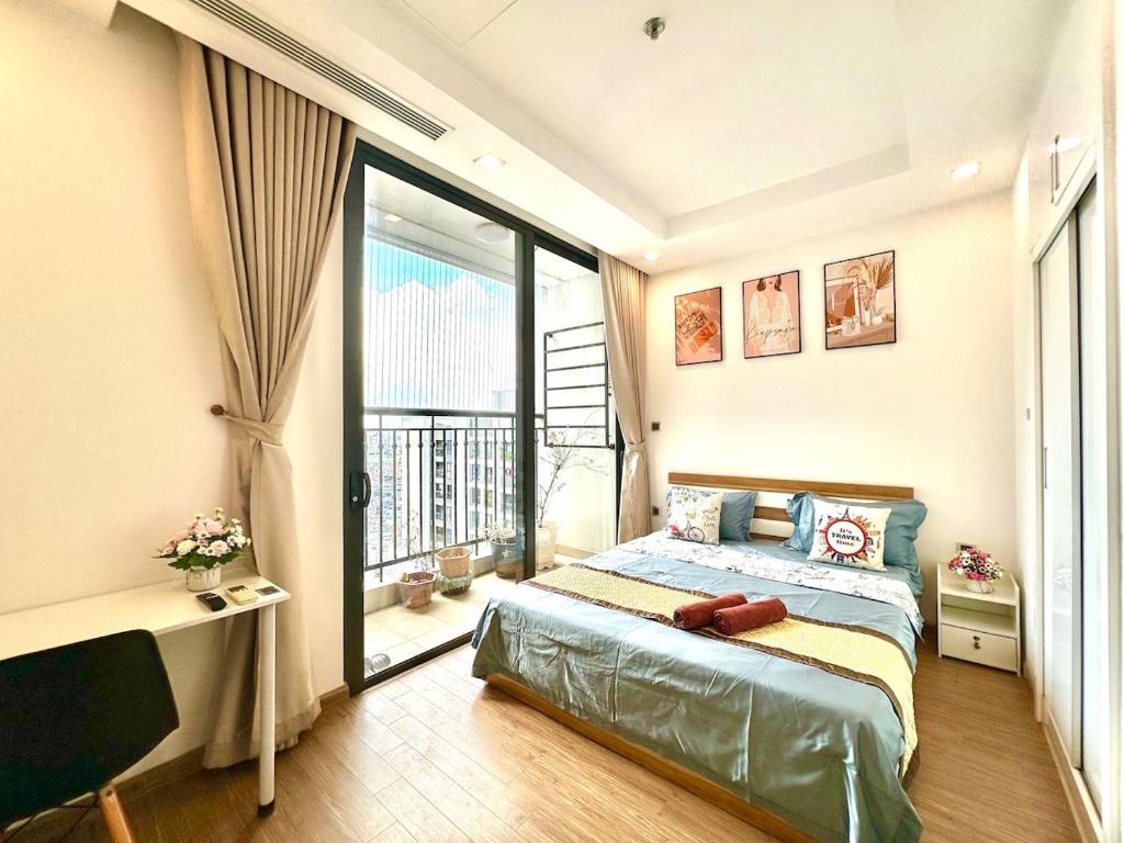 a bedroom with a bed and a large window at Fully Furnished Studio, 5 Star Class Apt With Gym, Pools, Tennis Yard & Other Outdoor Sport in Hanoi