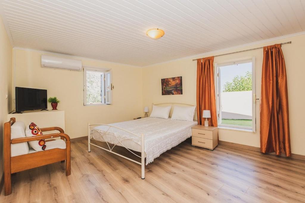 sypialnia z łóżkiem i dużym oknem w obiekcie Angels’ Home- Modern & Comfy, Fully equipped 3BD w mieście Dhrápanos