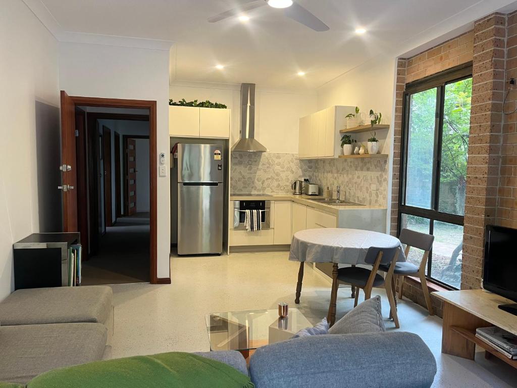 KurrajongMountain View Blue Mountains的客厅里有一张沙发和一个厨房