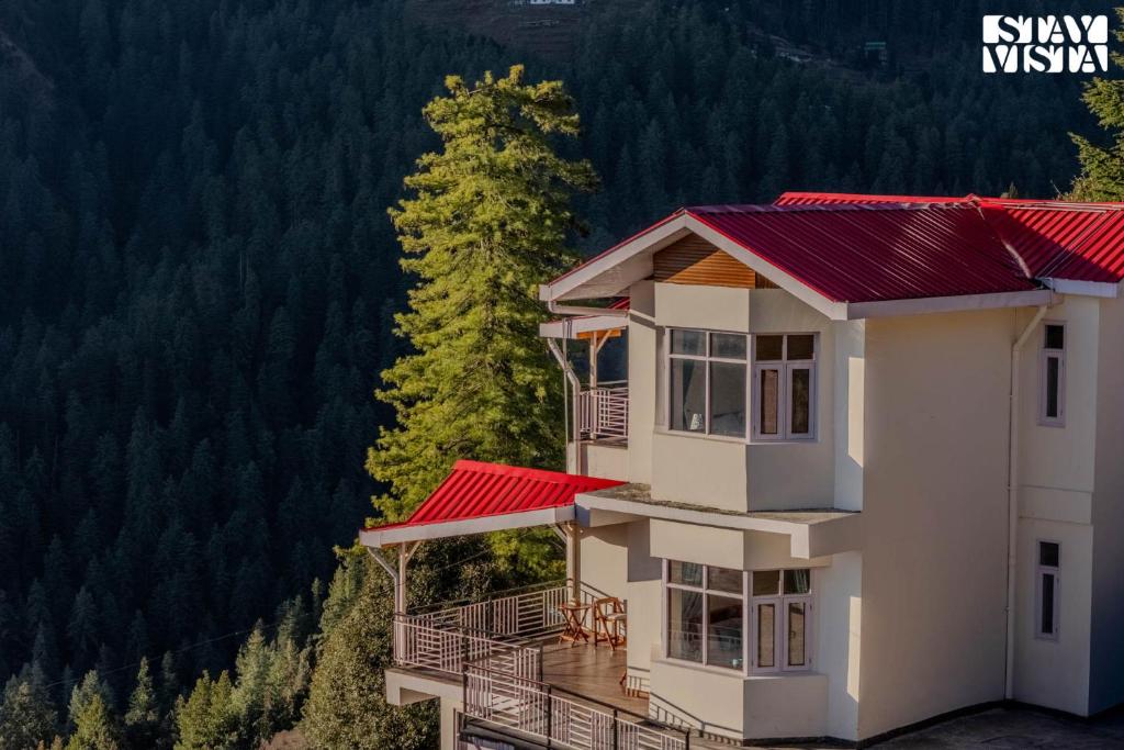 a house with a red roof in the mountains at StayVista at Saraiya House with Bonfire & WiFi in Shimla