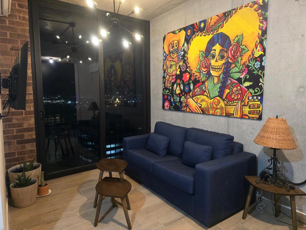 a living room with a blue couch and a painting at 1609 Barrio W in Monterrey