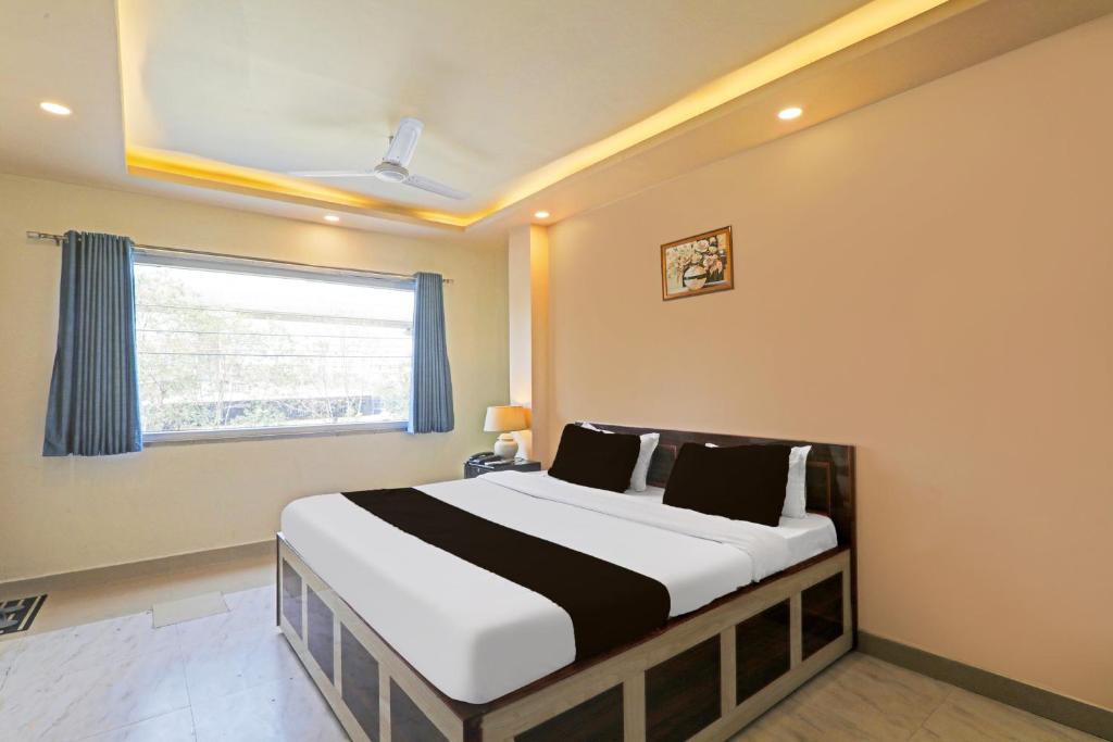 a bedroom with a large bed with a window at Hotel Kalpana in Patna