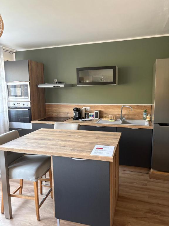 une cuisine avec une table et un comptoir dans l'établissement Studio lumineux et élégant - parking gratuit, à Chambéry