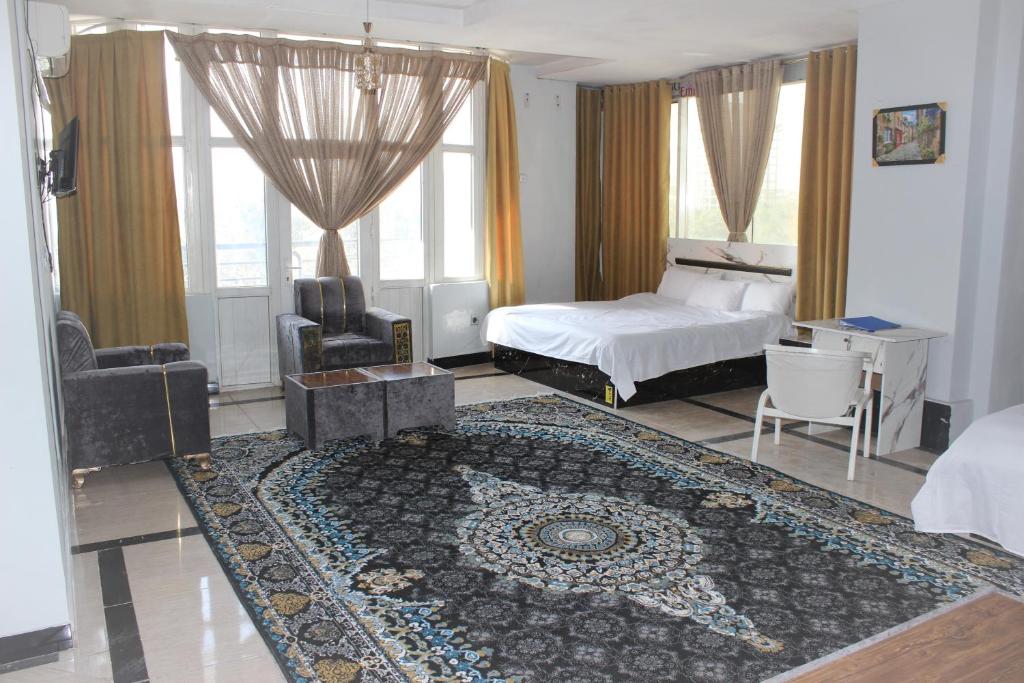 Shahr-e NowClock Tower Hotel的一间卧室配有一张床、一张桌子和一张地毯。
