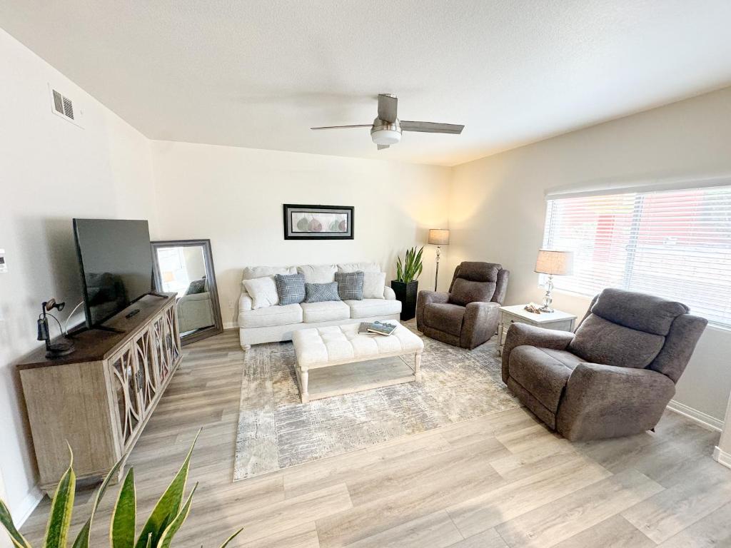 a living room with a couch and two chairs and a tv at Newly Renovated Condo in Mesquite