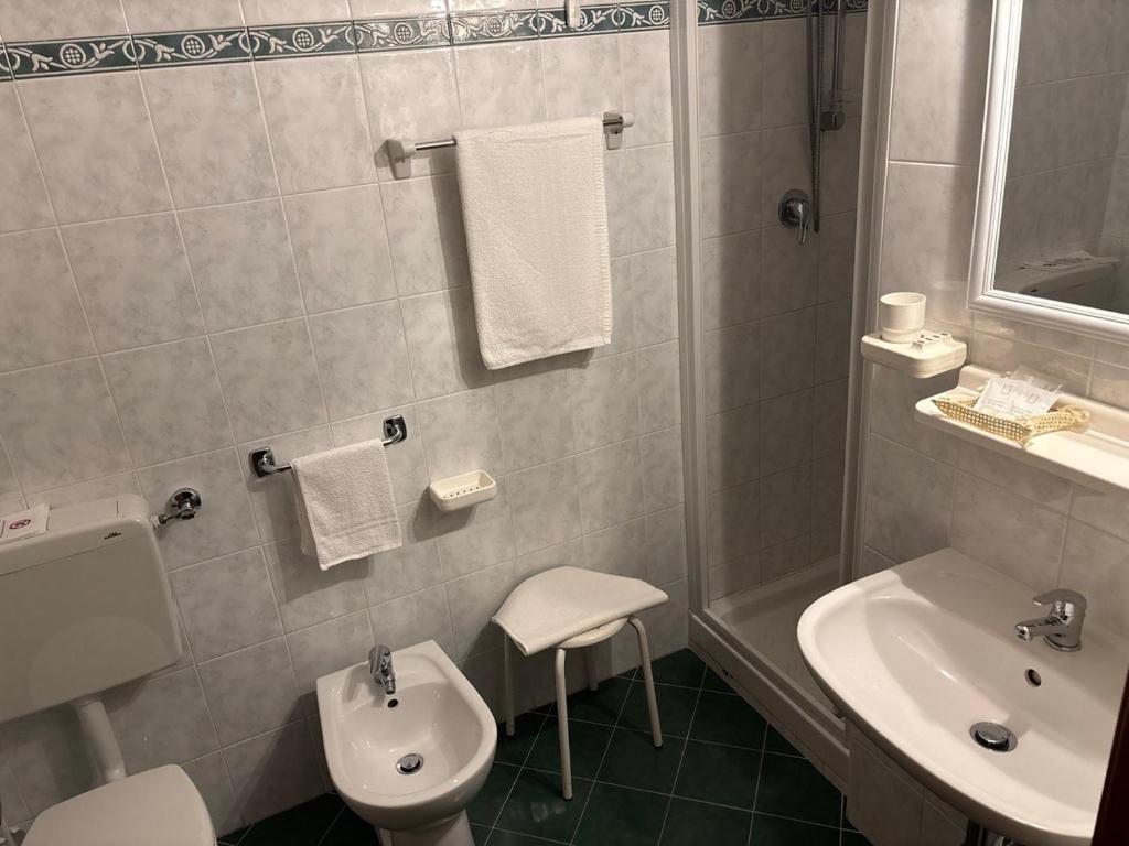 biała łazienka z umywalką i toaletą w obiekcie Albergo Edera w mieście Salsomaggiore Terme