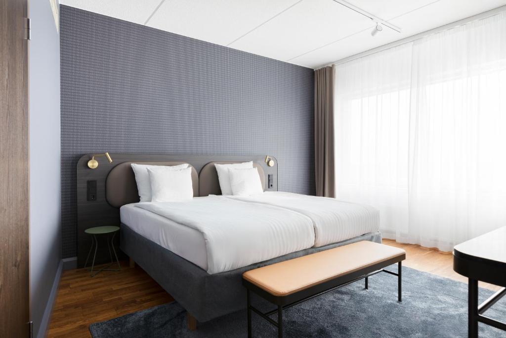 a bedroom with a large bed and a table at Break Sokos Hotel Flamingo in Vantaa