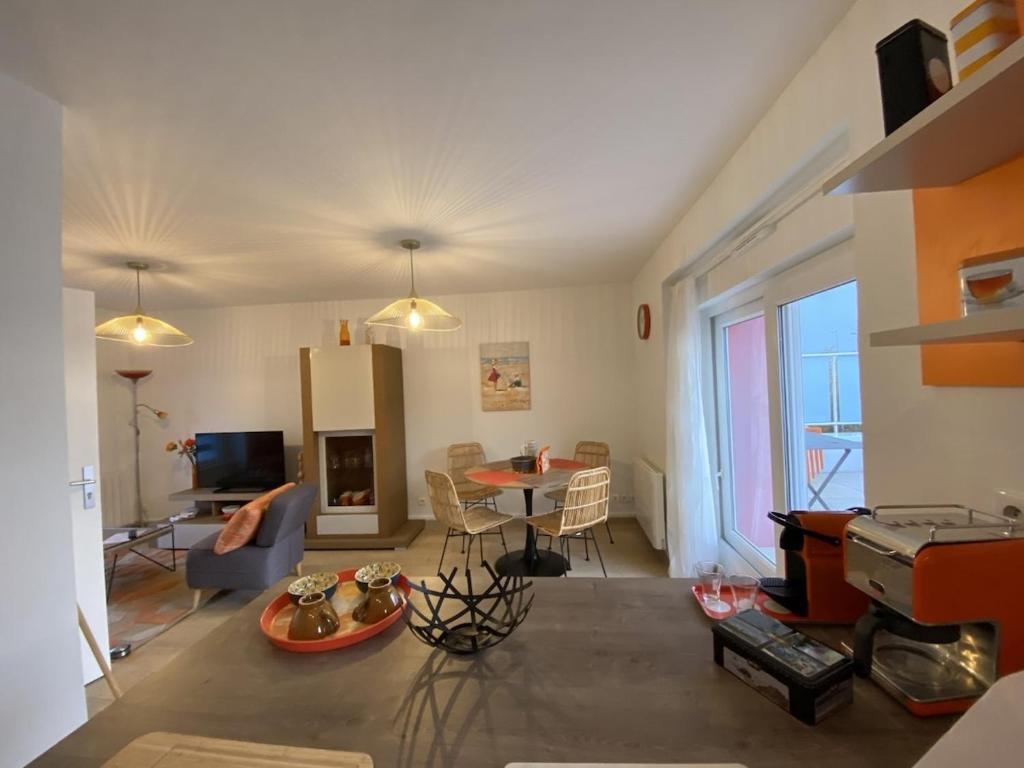 a living room with a table and a dining room at Le Mandarine, T2 proche plage de Morgat in Crozon